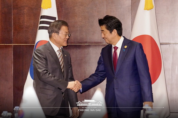 President Moon Jae-in of Korea(Left) shakes hands with Japanese Prime Minister Shinzo Abe