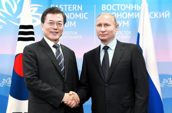 President Moon Jae-in (left) and President Vladimir Putin of Russia shake hands with each other at the Korea-Russia summit meeting at the Far Eastern University of Vladivostok.