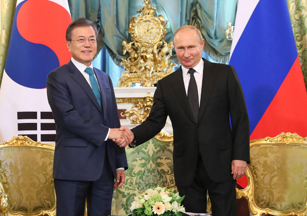 President Moon Jae-in, left, and Russian President Vladimir Putin shake hands with each other during a meeting at the Kremlin in Moscow on June 22, 2018