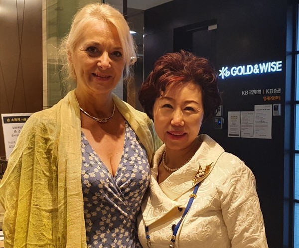 Mrs. Flavia Athena Kloos (spouse of the ambassador of Romania), left, poses with Vice Chairperson Mrs. Joy Cho of The Korea Post media. Madam Kloos is the president of the Ambassadors’ Spouses Association in Seoul).