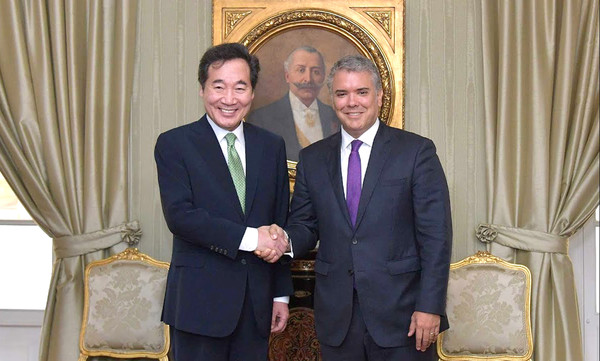 Prime Minister Lee Nak-yon, left, shakes hands with Colombian President Ivan Duque Marquez at the latter's office in Bogota on May 6. 2019