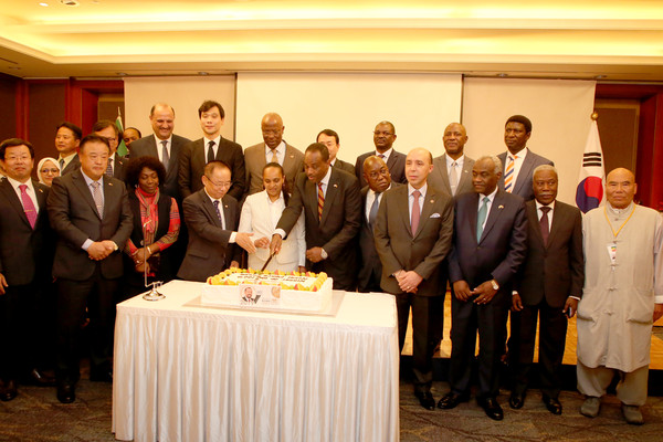 Ambassador Shigutie of Ethiopia (sixth from left, front row) cuts a celebration cake with guests. At far right is Head Priest Park of the Cheonman-sa Buddhist Temple in Ulsan.