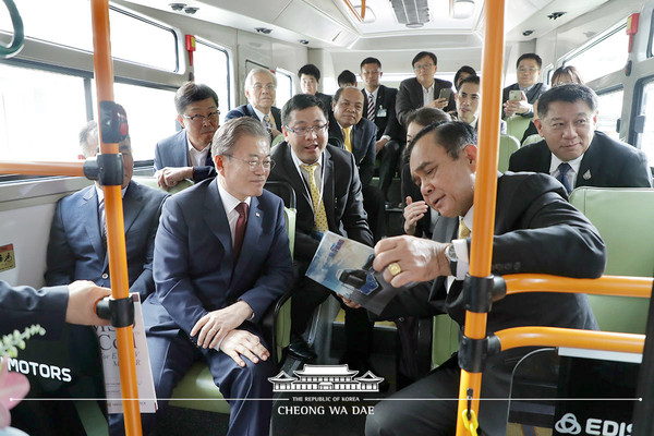 President Moon Jae-in of Korea (left, foreground) and Prime Minister Prayut Chan-o-cha of Thailand (right, foreground) discuss tourist attractions in each other’s country with a view to promoting tourist exchanges between the two countries. Leaders of the two countries are onboard one of the deluxe buses of Edison Motors.