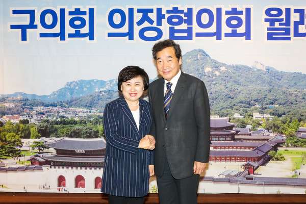 Chairperson Choi Yoonnam of the Nowon District Council in Seoul (left) shakes hands with Chairman Lee Nak-yon of the ruling Democratic Party at a Seoul City Council leaders meeting in Seoul in August 2020.