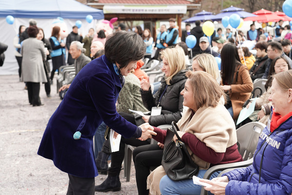 Chairperson Choi shakes hands with an expatriate lady in Seoul at a meeting in 2019 on the occasion of a commemoration meeting of the World Down Syndrome Day