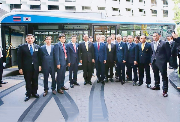 문재인 대통령과 쁘라윳 찬 오차 태국 총리(앞줄 왼쪽에서 여섯 번째와 일곱 번째)가 에디슨 모터스의 고급 버스 앞에서 카메라를 향해 포즈를 취하고 있다. 에디슨 모터스 강영권 회장이 찬 오차 총리의 뒤를 이었다
