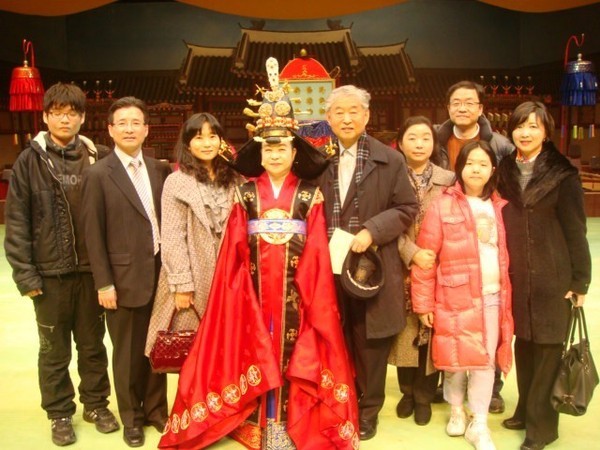 Lady Novelist Han Malsook (in traditional Korean royal costume) and her late husband (noted Korean Gayageum Specialist Hwang Byung-ki (fourth and fifth from left, respectively) pose with their family members.