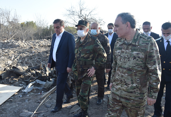 An Azerbaijan senior military officer (right, foreground) inspects a damaged village.