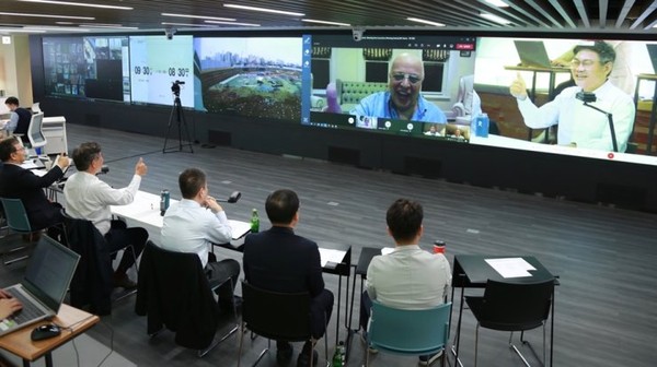 SK E&C CEO Ahn Jae-hyun, right on screen, gestures during an online meeting with Veea CEO Allen Salmasi, left on screen, to sign an MOU for the bilateral partnership on Oct. 21./ Courtesy of SK E&C