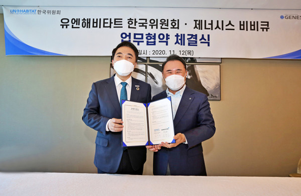 Genesis BBQ Chairman Yoon Hong-geun (right) poses with Park Soo-hyun, chairman of the Korean Committee of the U.N. Habitat in an event to sign an MOU for the business cooperation on Nov. 12.