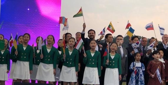 오시오 부스티오스 대리 대사(오른쪽에서 7번째, 뒷줄)는 문화 행사에서 다른 대사와 어린이들과 함께 자국 국기를 흔들고 있다