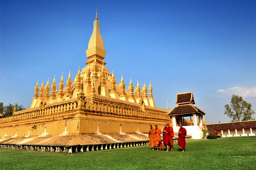 Lao Buddhist priests with their majestic That Luang Stupa, Vientiane Capital.