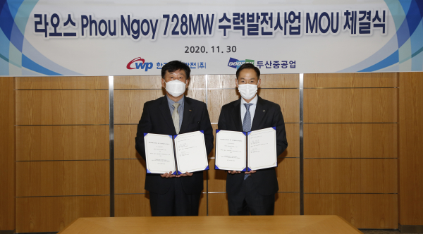 Song Jae-sup (left), head of the planning management division of Korea Western Power, and Park In-won, head of Plant EPC BG of Doosan Heavy Industries & Construction, are taking a commemorative photo after signing the MOU for the Laos hydroelectric project held at Doosan Heavy Industries' Seoul office on Nov. 30/ Courtesy of Doosan Heavy Industries 
