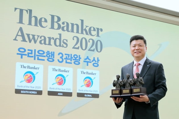 Woori Bank CEO Kwon Kwang-seok is taking a commemorative photo with three award trophies at the 2020 Bank of the Year award ceremony held online. / Courtesy of Woori Bank