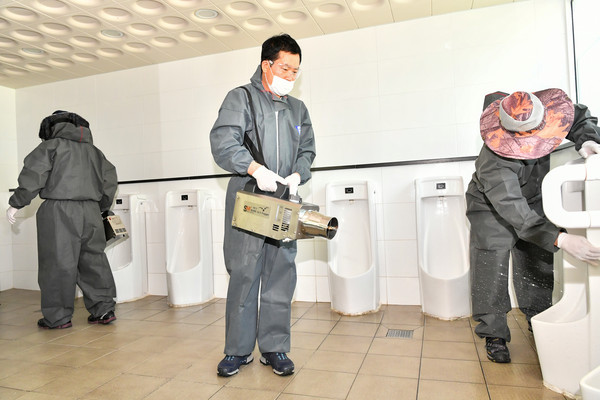 홍순헌 해운대구청장(가운데)이 부산 해운대구의 화장실 소독에 솔선 수범을 하고 있다