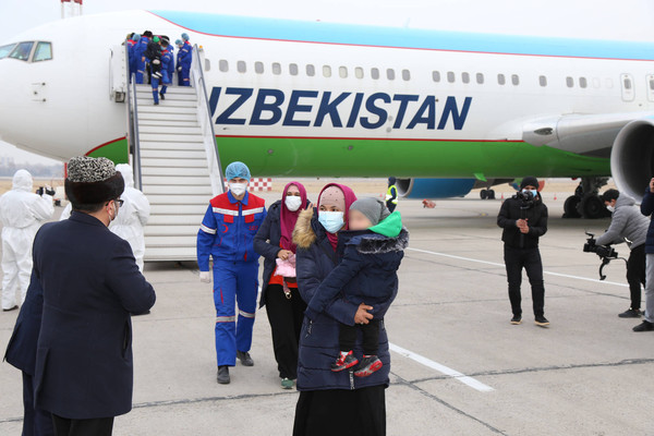 People disembark from a plane upon their arrival from Syria at an airport in Tashkent, Uzbekistan December 8, 2020
