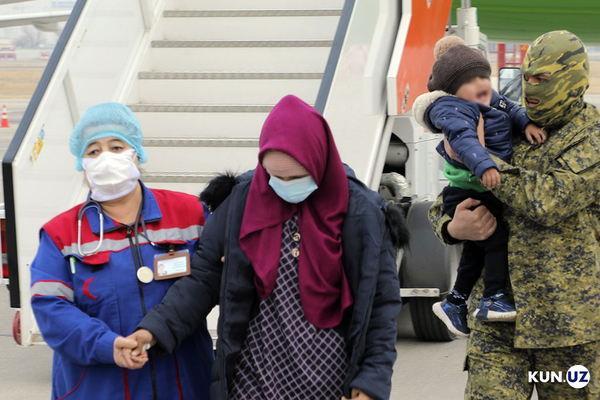 Medical staff helps women and children landed from Syria where they had been staying at camps with other families of Islamic State fighters