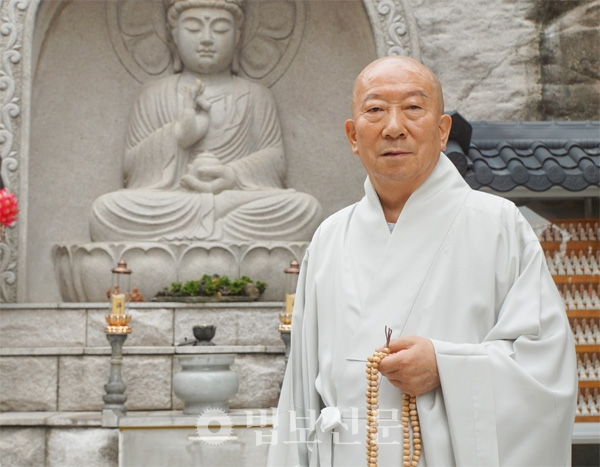 Venerable Hongpa in front of the granite image of Buddha at his temple in the heart of Seoul. (Photo: Beopbo Shinmun Buddhist newspaper)