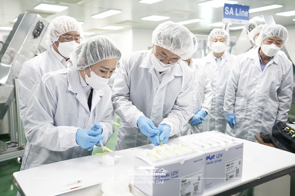 President Moon Jae-in (second from left, front row) checks syringes for injecting vaccines against COVID-19 at a factory of the medical device manufacturer Poonglim Pharmatech in Gunsan, Jeollabuk-do Province on Feb. 18./ Courtesy of Cheong Wa Dae