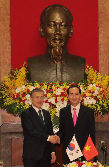 President Moon Jae-in (left) shakes hands with the then Vietnamese President Tran Dai Quang at a joint press conference in Hanoi, Vietnam on March 23, 2018.