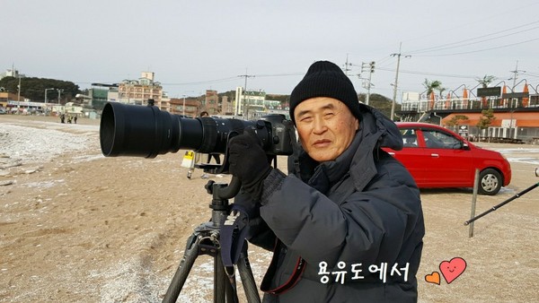 용유도 해변가에서 대형 카메라를 들고 촬영하고 있는 탐조 사진작가 김흥록
