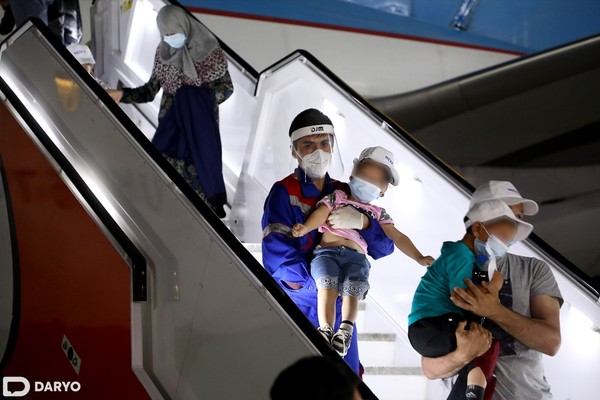 People walk down the stairs  from a plane on their arrival from Syria at an airport in Tashkent, Uzbekistan, on April 30, 2021 (photo: daryo.uz)