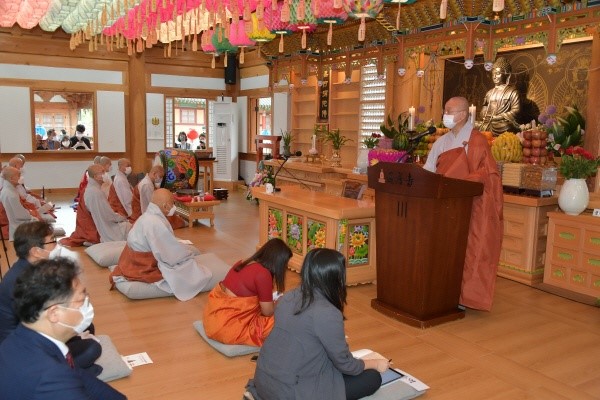 Chief Abbot Ven. Hyeonmun of the Tongdosa Buddhist Temple (behind rostrum) speaks to a meeting of the guests and Buddhist monks at his temple.