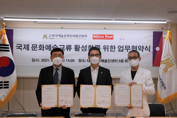Lee Bum-hun (center), chairman of the FACO, Kevin Lee (left), managing editor of the Korea Post media, and Bae Hee-kwon, chairman of the WPFA, pose for the camera after signing a business pact at Korea Mok-dong Artists Center in Yangcheon-gu, Seoul.