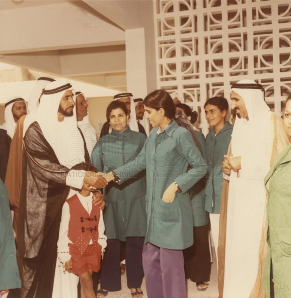 UAE Crown Prince Mohamed bin Zayed Al Nahyan shakes hands with a female worker to encourage her.