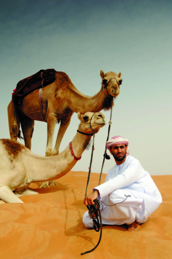 낙타와 함께 사막에 있는 여행자