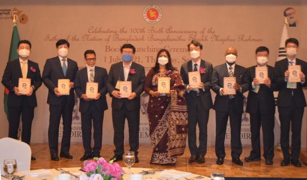 Amb. Abida Islam of Bangladesh (center), Rep. Sul Hoon (fourth from left) of the main Democratic Party of Korea, Lee Sang-ryol (fourth from right), director-general for Asian and Pacific Affairs Bureau, the Ministry of Foreign Affairs, MD. Shohidul Islam (Hasan, third from left), president of Skyhi Corp., and other guests pose for the camera with a book titled “The Unfinished Memoirs,” the autobiography of the Father of the Nation written in Korean, in their hands.