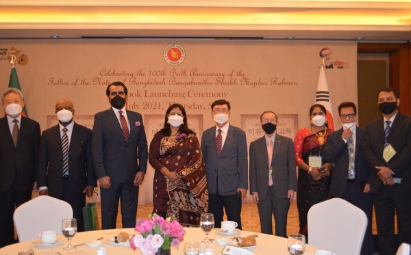 Amb. Abida Islam of Bangladesh (center), Rep. Sul Hoon (fourth from left) of the main Democratic Party of Korea, Lee Sang-ryol (fourth from right), director-general for Asian and Pacific Affairs Bureau, the Ministry of Foreign Affairs, and other guests pose for the camera with a book titled “The Unfinished Memoirs,” the autobiography of the Father of the Nation written in Korean, in their hands.