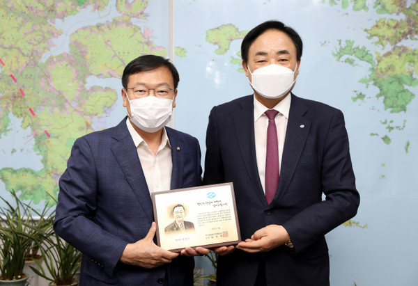 Lim Joon-taek (right), chairman of the National Federation of Fisheries, delivers a plaque of appreciation to Rep. Chung Jeom-sik of the People Power Party at the National Assembly on July 7.
