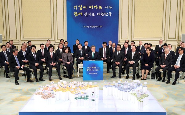 President Moon Jae-in (center) speaks of a meeting with business leaders.