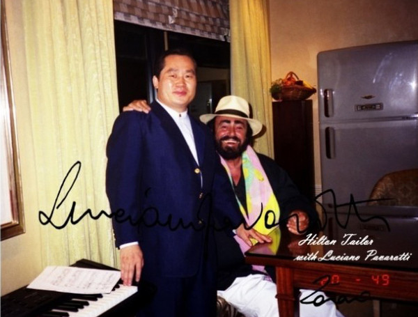 Chairman Hilton Lee (left) and the world-famous tenor Luciano Pavarotti (seated) pose for the photo.
