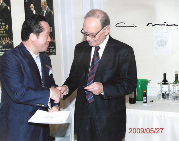 Ennio Morricone shaking hands with Chairman Hilton Lee (left)
