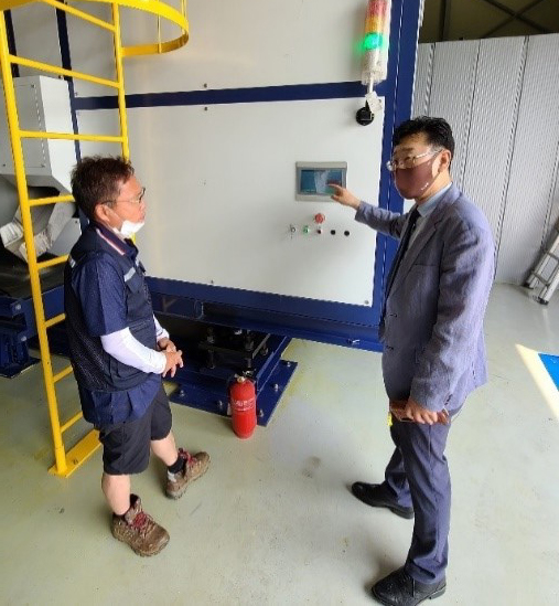 JC Global CEO Kim Gyeong-rea talks with a plant manager operating the food waste disposer.