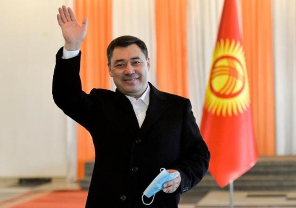 President Sadyr Japarov of the Kyrgyz Republic raises his hand in response to his supporters.