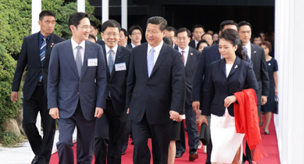 President Xi Jinping of China (center, foreground) and Vice Chairman Lee Jae-yong of Samsung Business Group (left) are moving to the guesthouse after visiting the Samsung Electronics Exhibition Hall in Seoul on July 4, 2014.