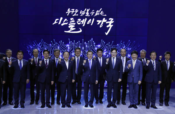 President Moon Jae-in and Vice Chairman Lee Jae-yong of the Samsung Business Group (8th and 10th from left, respectively) pose with government and local leaders at a Samsung plant in Asan, Chungcheongnam-do province. The sign above them reads: "For a display-strong Korea who must be reckoned with!" 