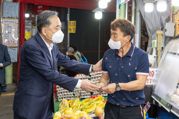 박차훈 새마을금고중앙회장(왼쪽)이 울산신정시장에서 과일을 구매하며 상인과 담소를 나누고 있다
