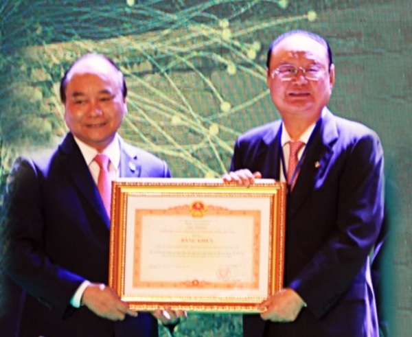 Chairman Lee Dae-bong of Charm VIT Group (right) receives a commendation from the Vietnamese Prime Minister Nguyen Xuan Phuc in Hanoi on June 17, 2018.