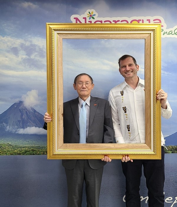 Ambassador Rodrigo Coronel Kinroch of Nicaragua in Seoul (right) and Publisher-Chairman Lee Kyung-sik of The Korea Post media take a picture, holding a frame set up at the Nicaraguan Embassy in Seoul on Oct. 18.