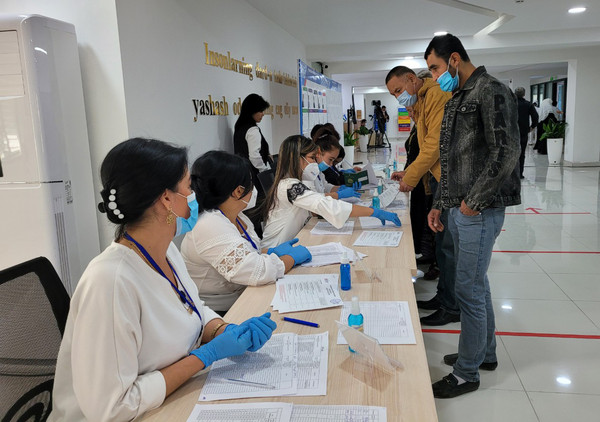 예비 투표인들이 선거인단 투표소에서 이름을 확인하고 있다.
