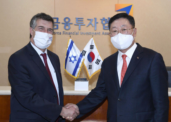 Na Jae-chul, chairman of the Korea Financial Investment Association (right) and Ambassador Akiva Tor of Israel in Seoul shake hands before holding a consultative meeting in Seoul on Nov. 9.