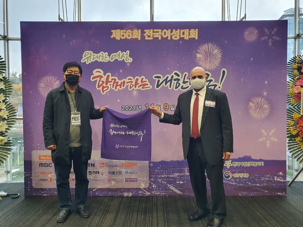 Ambassador Bader Mohamed Ibrahim al-Awadi of Kuwait to Korea (right) and Vice Chairman Song Na-ra of Korea Post pose for a commemorative photo with a handkerchief holding the slogan 'Great women, Korea together!'.
