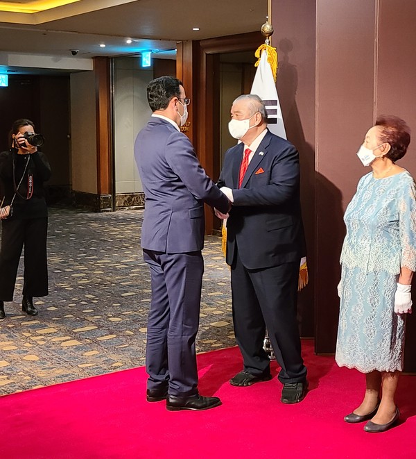 Ambassador Fen of Uzbekistan (center) welcomes Ambassador Ramzi Teymurov of Azerbaijan (left) while Madam Fen looks on at right.
