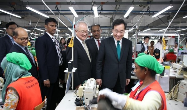 Ruling party leader, Lee Nak-yeon (right, stnading), with chairman Sung Ki-hak (third form left, foregroud) inspects overseas production facilities.