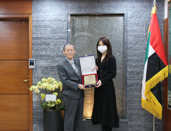 Publisher-Chairman Lee Kyung-sik of The Korea Post media presents a Plaque of Citation to Translator Kim Su-jin  (right) of the UAE Embassy in Seoul for the unreserved support given in the successful publication of a Special Report on the UAE.