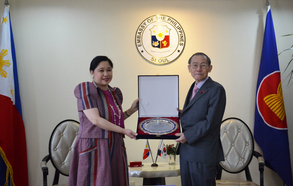 Ambassador Maria Theresa B. Dizon-De Vega of the Republic of Philippines in Seoul (left) is presented with a Plaque of Citation by Publisher-Chairman Lee Kyung-sik of The Korea Post media at the Embassy of Philippines in Seoul on Dec. 29, 2021. Ambassador Bizon-De Vega was cited for the exceptional and impeccable contents provided at an exclusive interview with her at the Embassy and also a high-quality Korean language translation of her answers provided by the Embassy, which were published by the Korean-language edition of The Korea Post (www.koreapost.co.kr). The costume whcih Ambassador Dizon-De Vega was wearing is a unique traditional Filipino dress is called Terno top with skirts, both made from Inavel fabric  handwoven in the Northern Philippines. The outfit is an original design by NinaInabel, a social enterprise promoting native Philippine weaves in modern, everyday design.